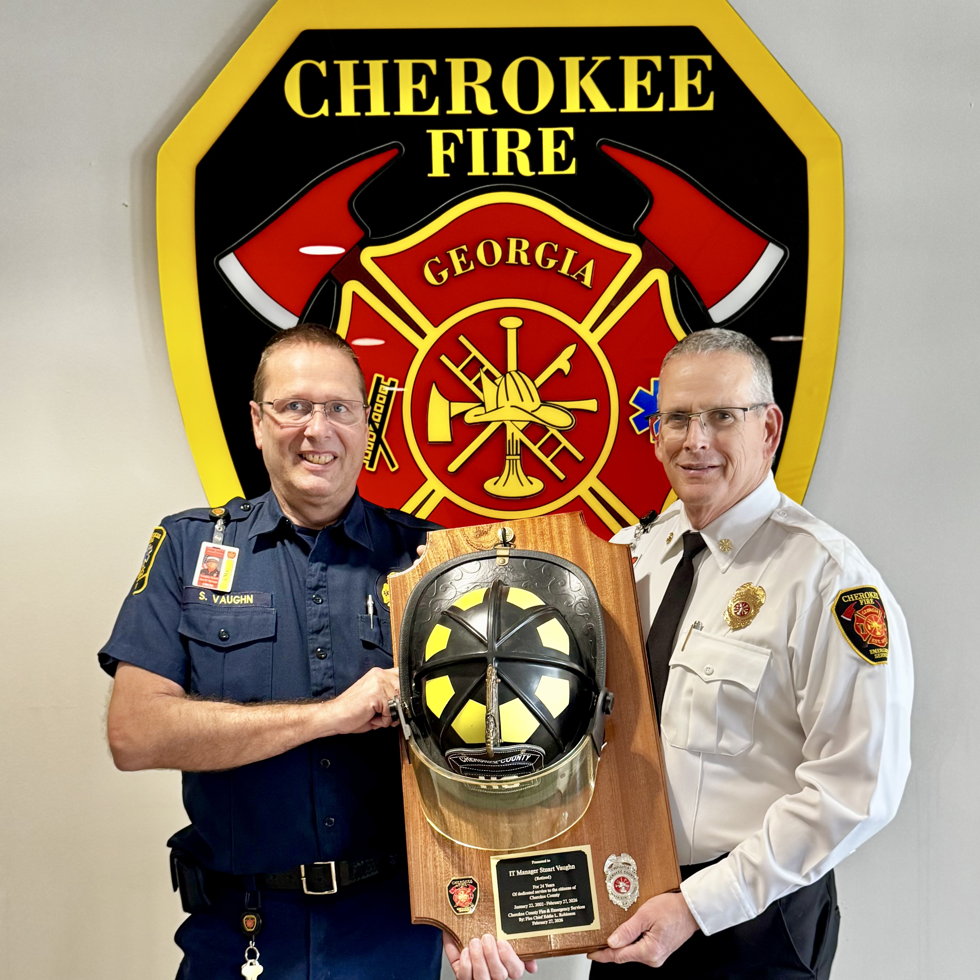 Chief Robinson (right) presents Stuart Vaughn (left) with a commemorative helmet plaque.  