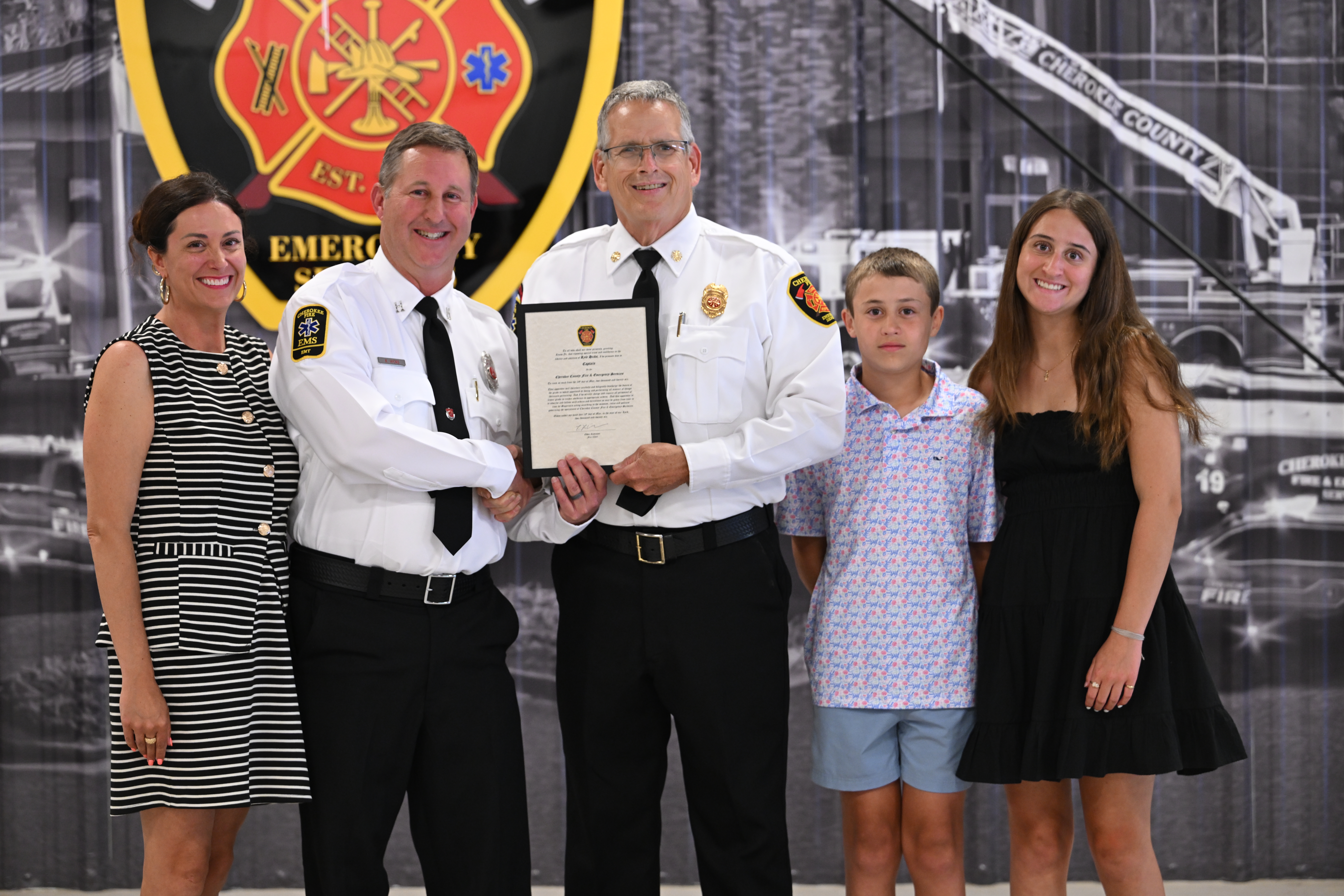 Chief Robinson congratulates Captain Hicks and his family. 