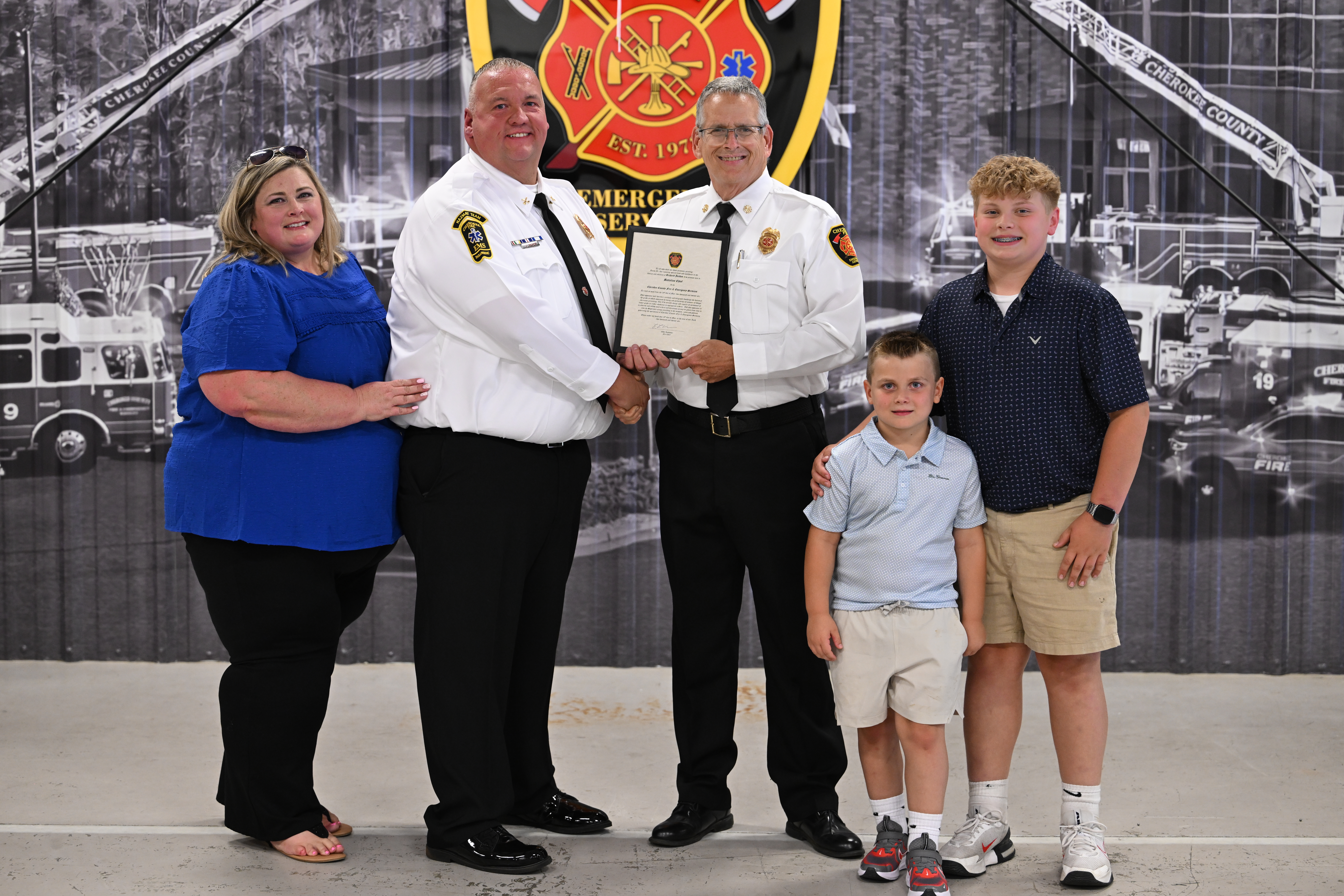 Chief Robinson congratulates Battalion Chief Richard Jordan and his family. 